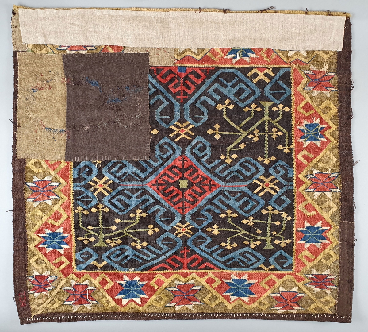 Putetrekk av billedvev, med tre-mønster i ranker. Mønsteret er avledet fra persisk mønster. Åttebladsroser langs kantene.