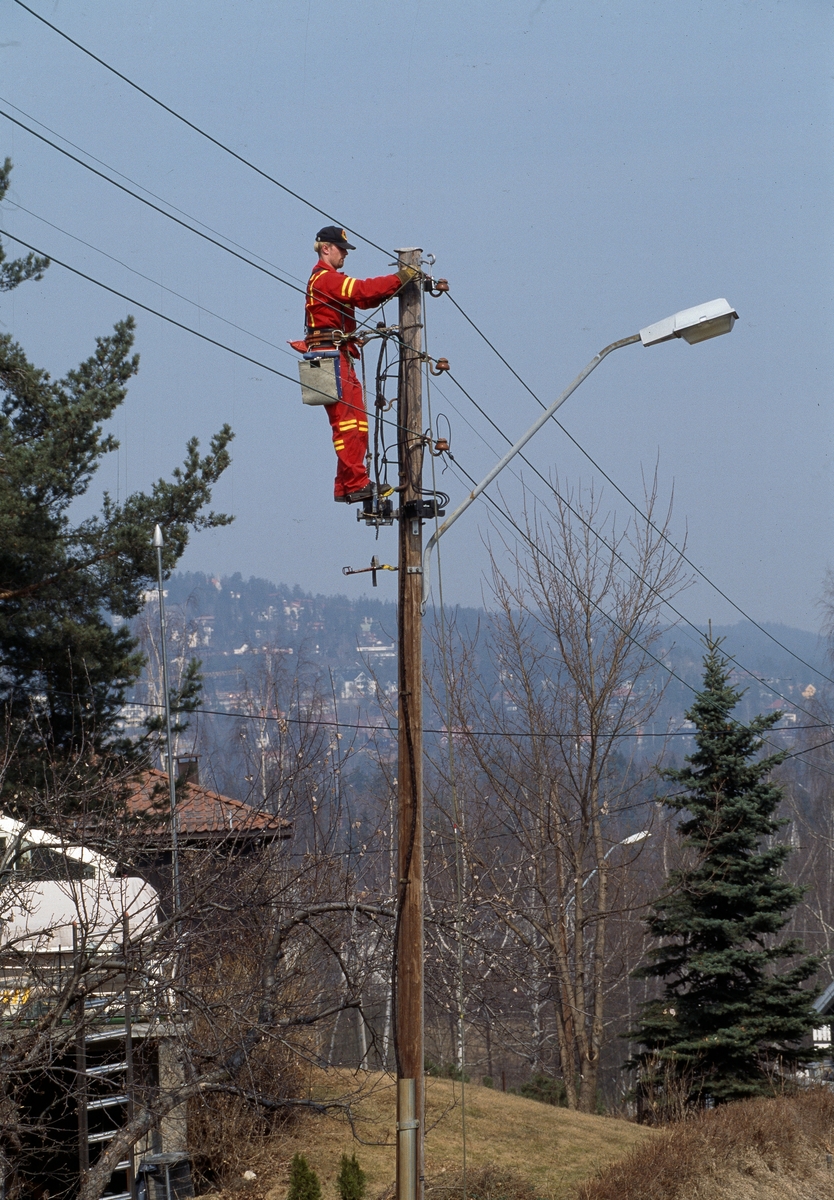 Elektrikere arbeider på en mast.