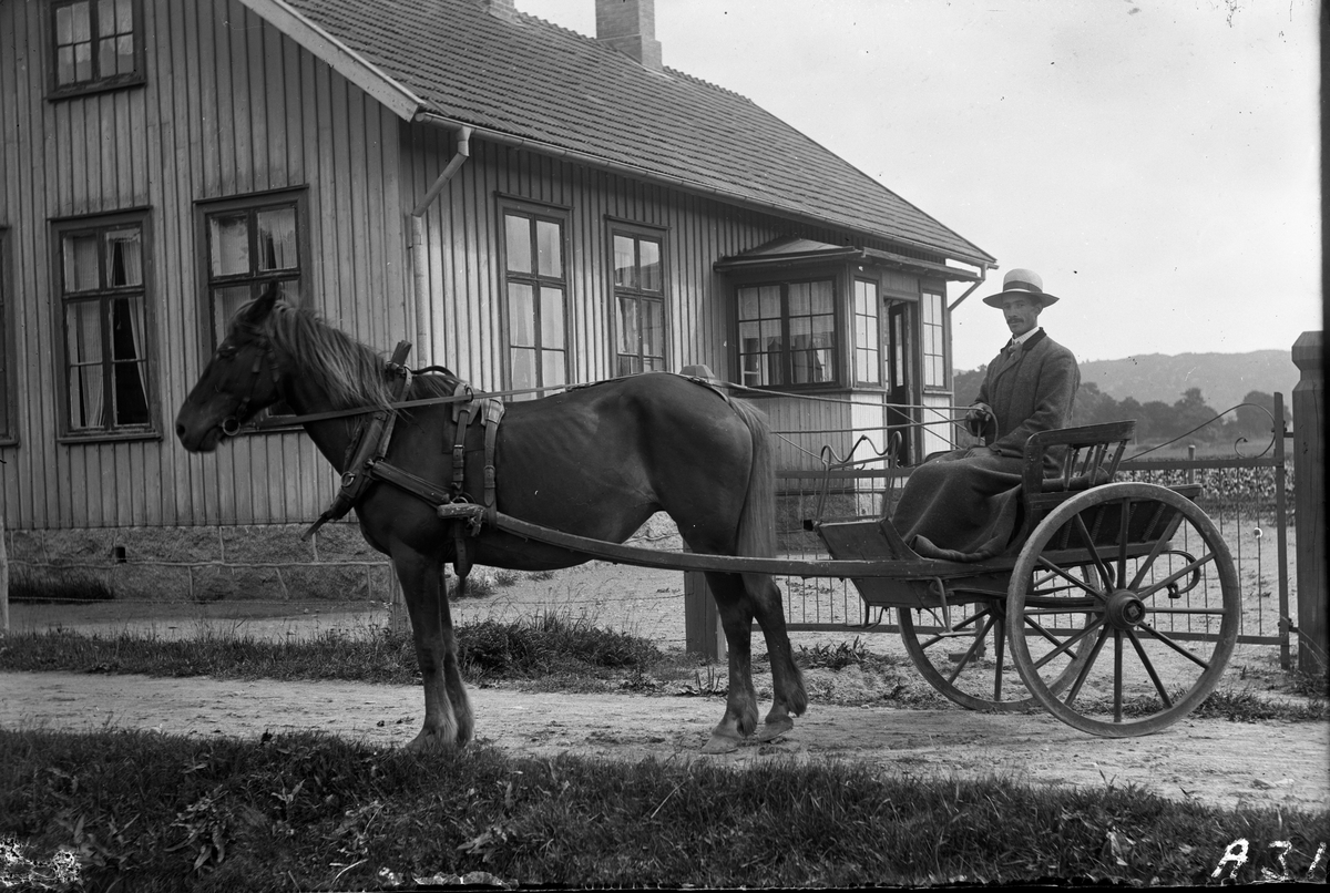 "Torkels-August" från Stora Råryd sitter i en gigg, dvs en ensitsig, tvåhjulig personvagn dragen av en häst. Byggnaden är småskolan i Sundbo, Sällstorp. Mannen heter egentligen August Johansson, men hans morfar, som hade gården tidigare, hette Torkel Larsson (f 1791).