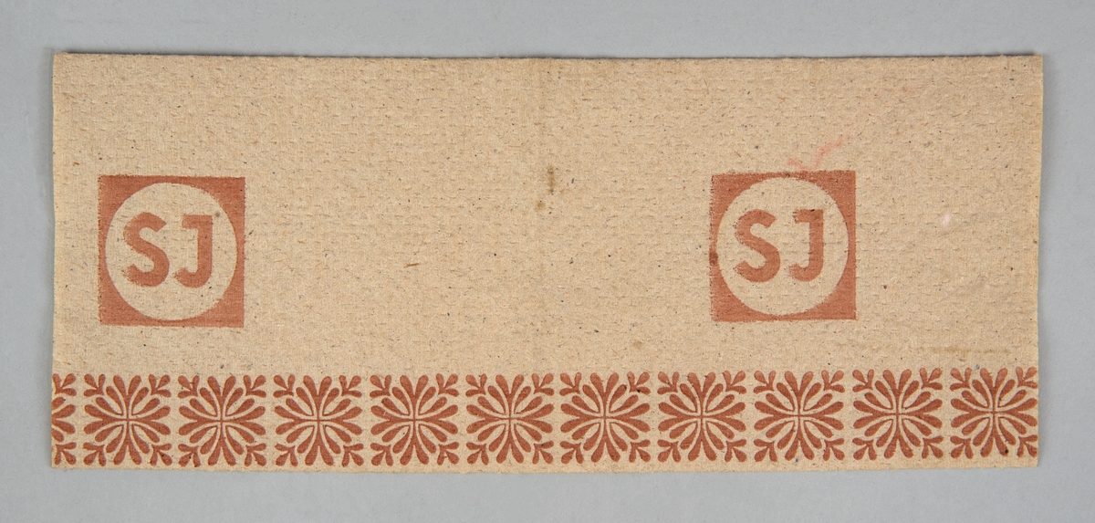 Pappershandduk med SJ:s logotyp och bladmönster tryckt i brunt. På baksidan står det "KATRIN FISKEBY AB KATRINEFORS BRUK MARIESTAD" tryckt i brunt.