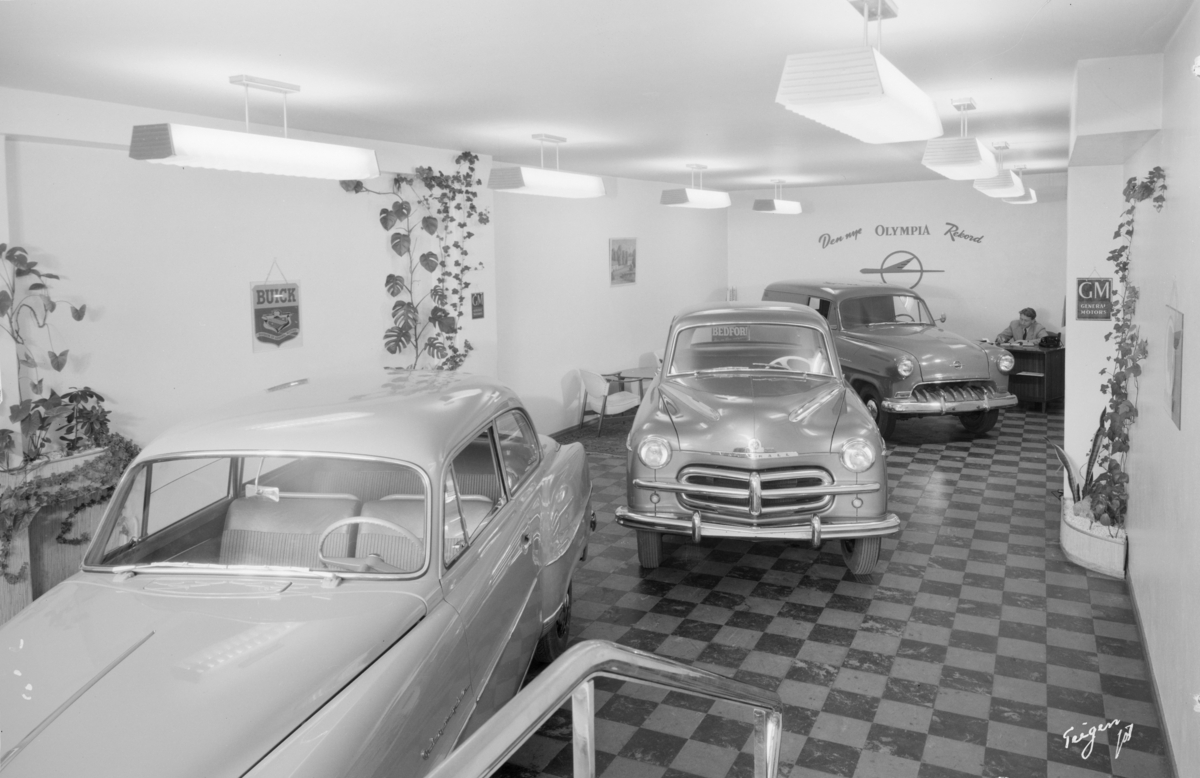 Bilde av butikklokalet i Gustav Thrane Steens Automobilforretning på Skøyen i Oslo. En Vauxhall og en Opel er stilt ut.