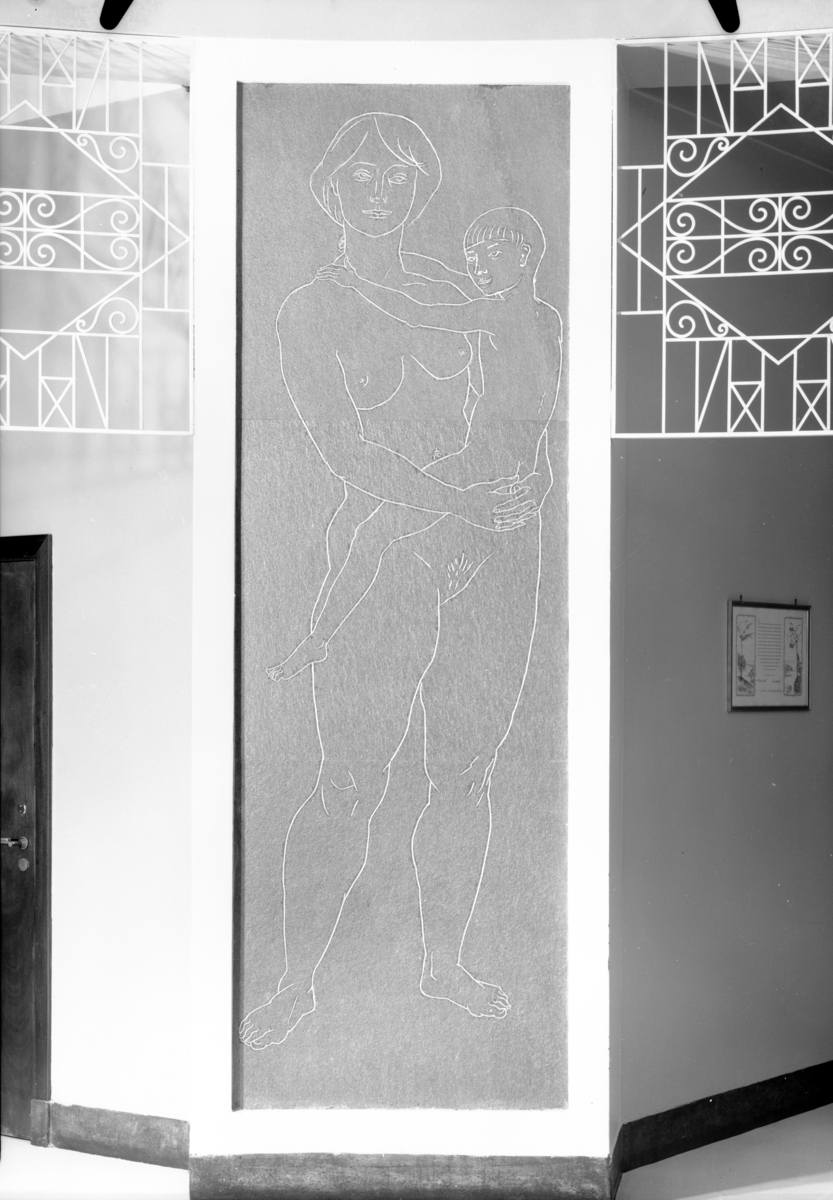 Detaljfoto av en veggdekorasjon på Freiafabrikken, forestiller en naken kvinne med et barn.