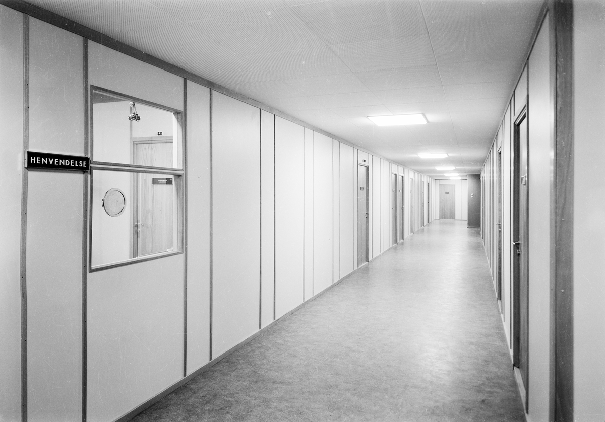 Interiørfoto av en gang med en resepsjonsluke i Høyblokka i Regjeringskvartalet.  Påskrift på  film: BO, 19