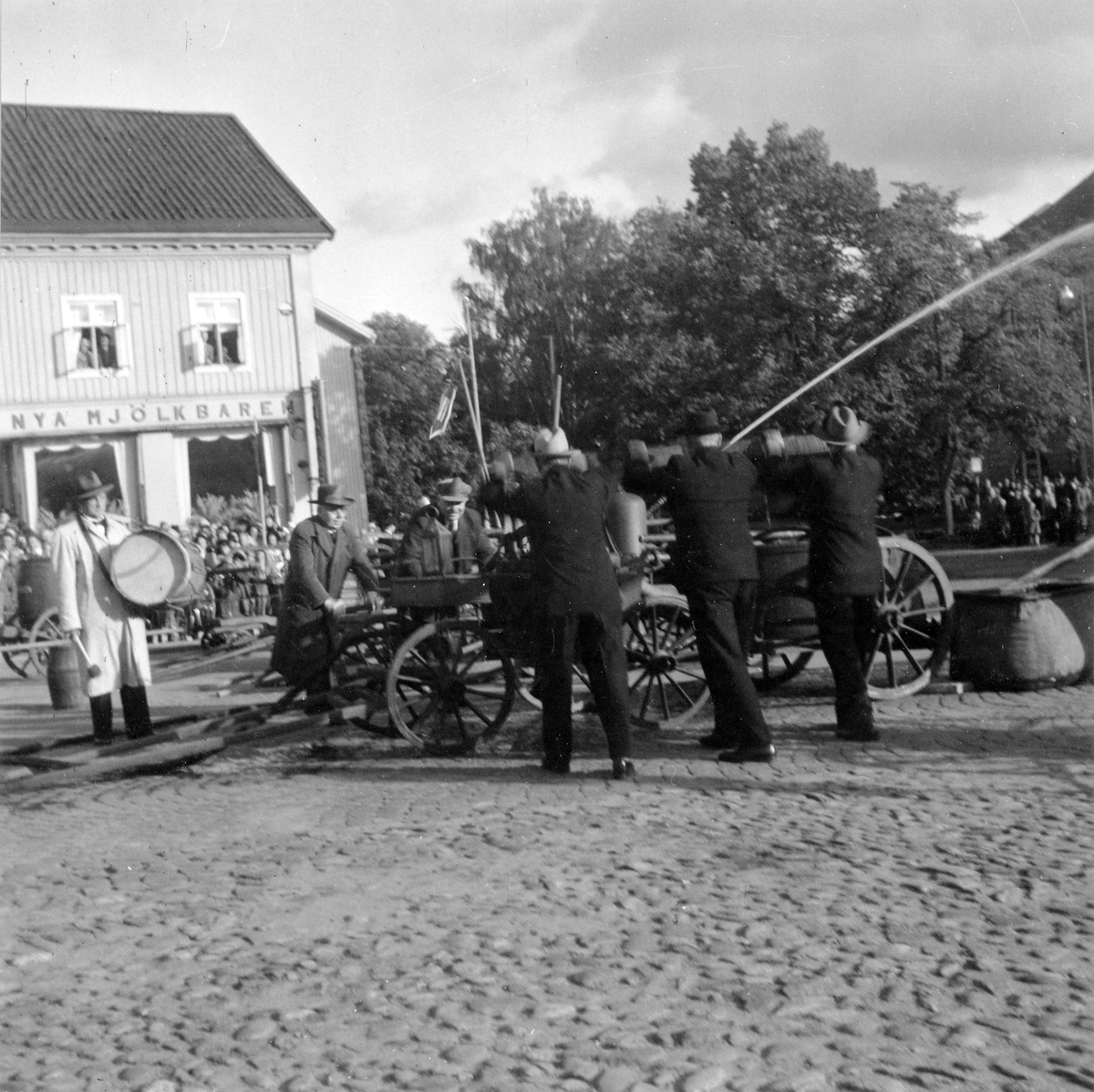 Alingsås Brandkårs 50års jubileum 1950. Brandkåren visar upp äldre brandsläckningsutrustning på Stora Torget i Alingsås.