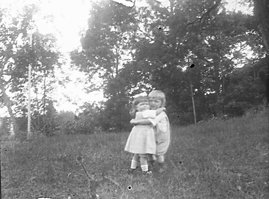 Grupporträtt, två barn i skogsdunge.