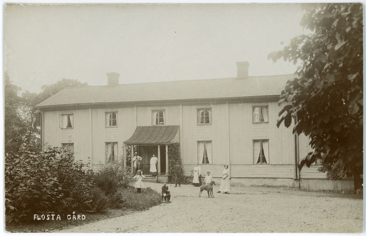 Kvinnor, barn och man framför huvudbyggnaden på Flosta säteri, Altuna socken, Uppland 1916