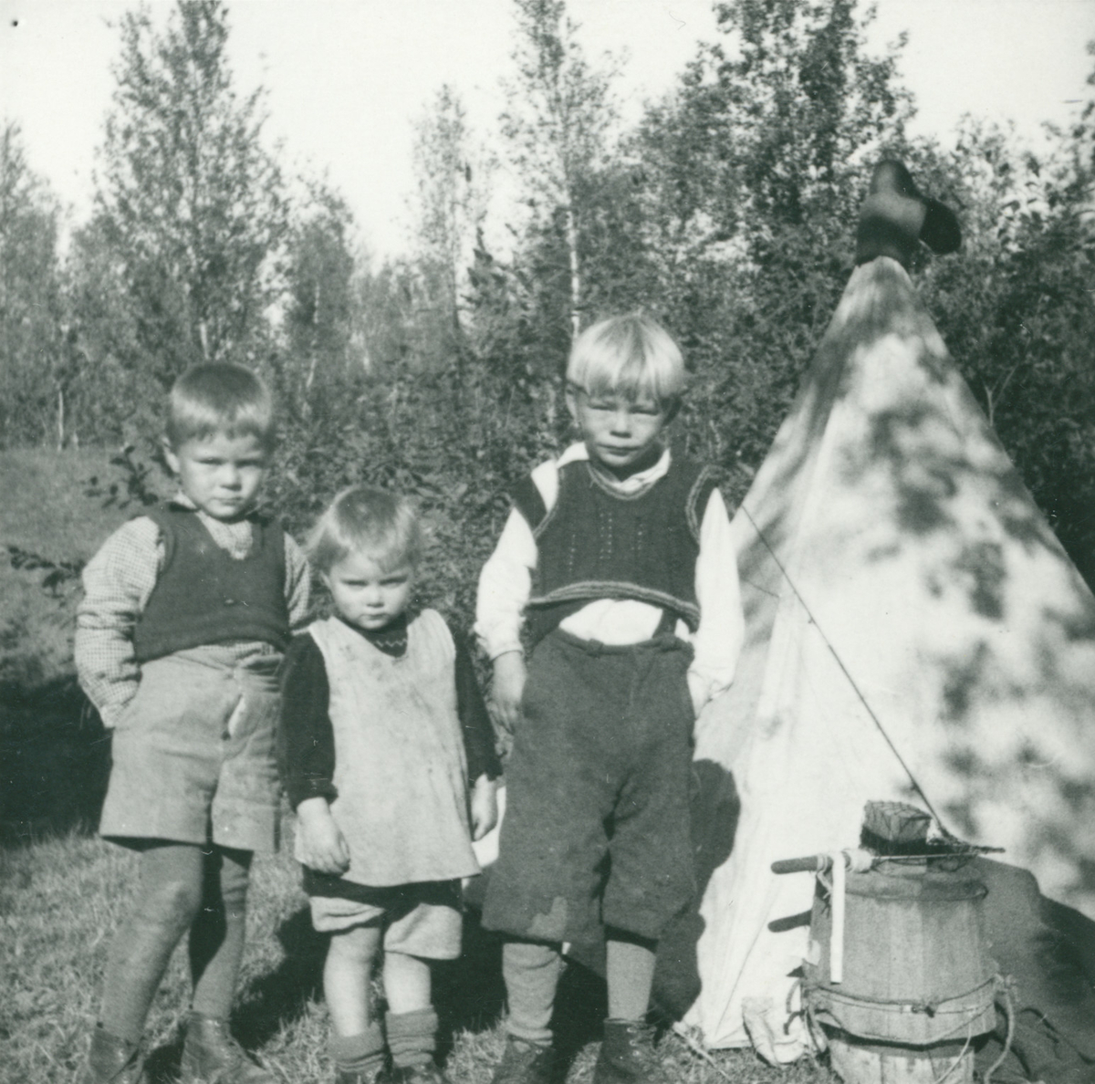 Tre barn foran et telt på Tømmernes.