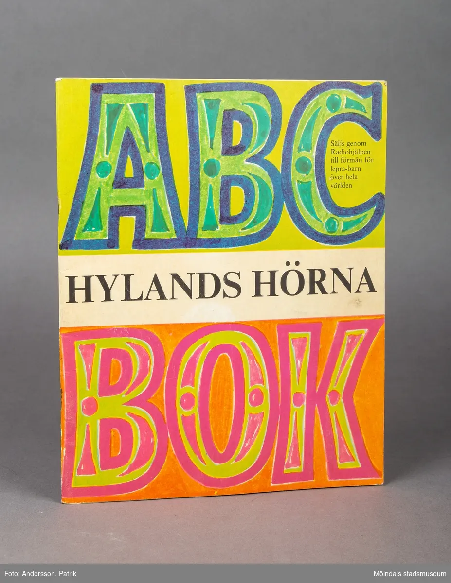 Ett häfte som innehåller verser skrivna till alfabetets alla bokstäver. Häftet är i A4 format och har en framsida med stor text som anger att det är en ABC bok. I mitten på framsidan står det Hylands Hörna med svarta versaler. Bokstäverna ABC är målade i grönt, turkost och blått. Längst ned står det bok skrivet med versaler i färgerna rosa, orange och ljusgrönt. I mitten inuti bokstaven C uppe till höger står det: Säljs genom Radiohjälpen till förmån för lepra-barn över hela världen.