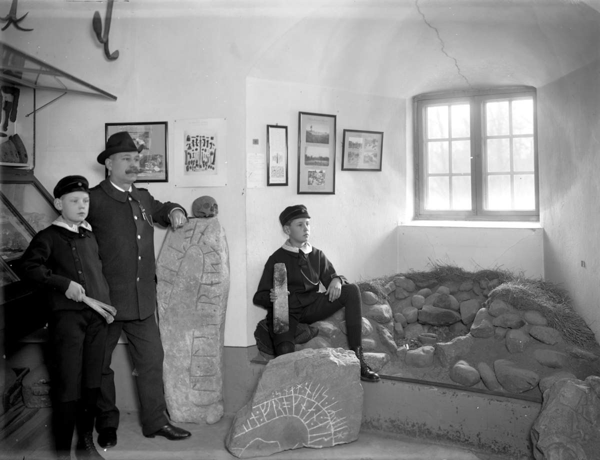 Örebro Läns Museum, Slottet.
Runstenar, två pojkar och en man.
Hugo Hedberg