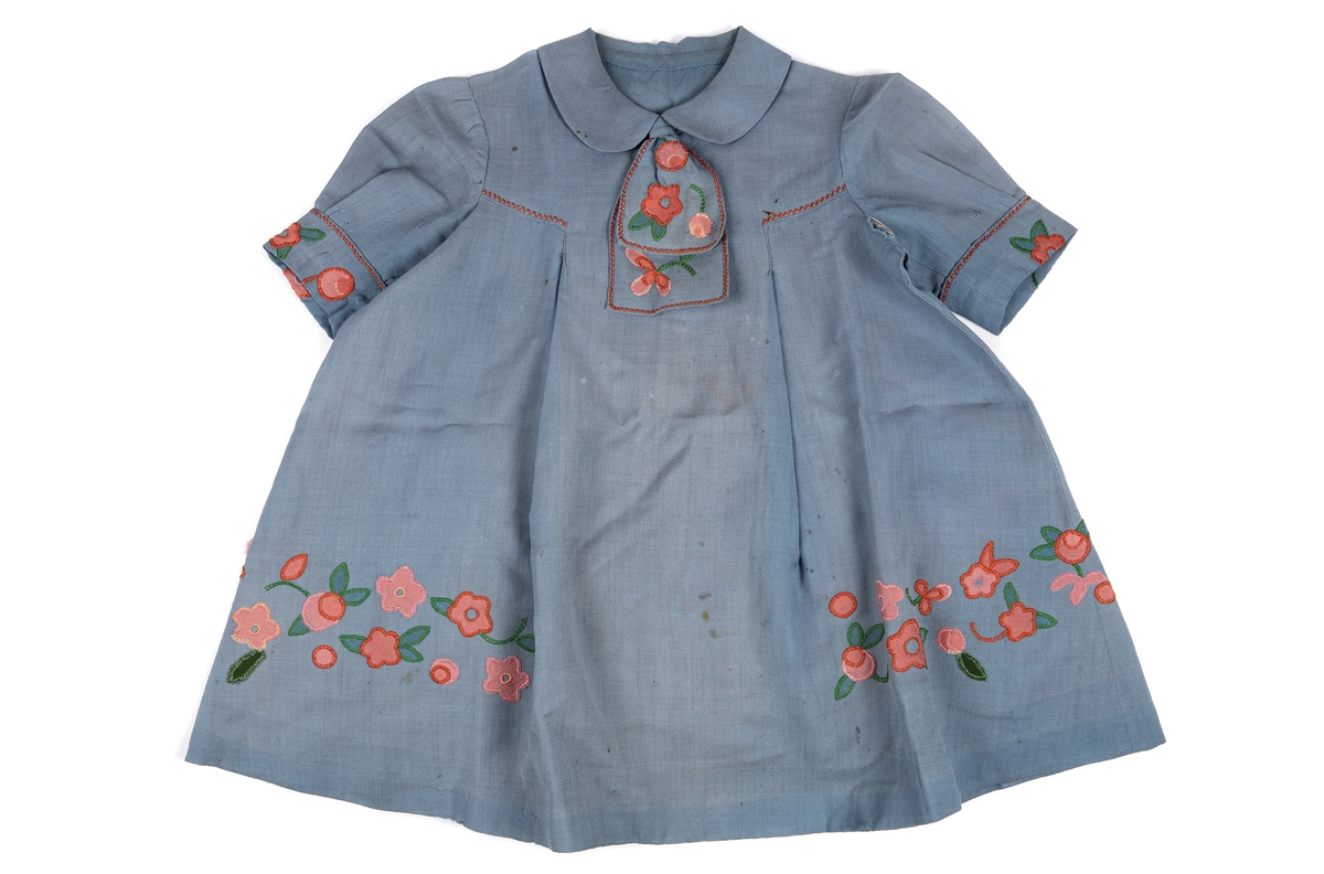Blå klänning för barn. Medtogs på flykt från Estland till Sverige 1944. 
