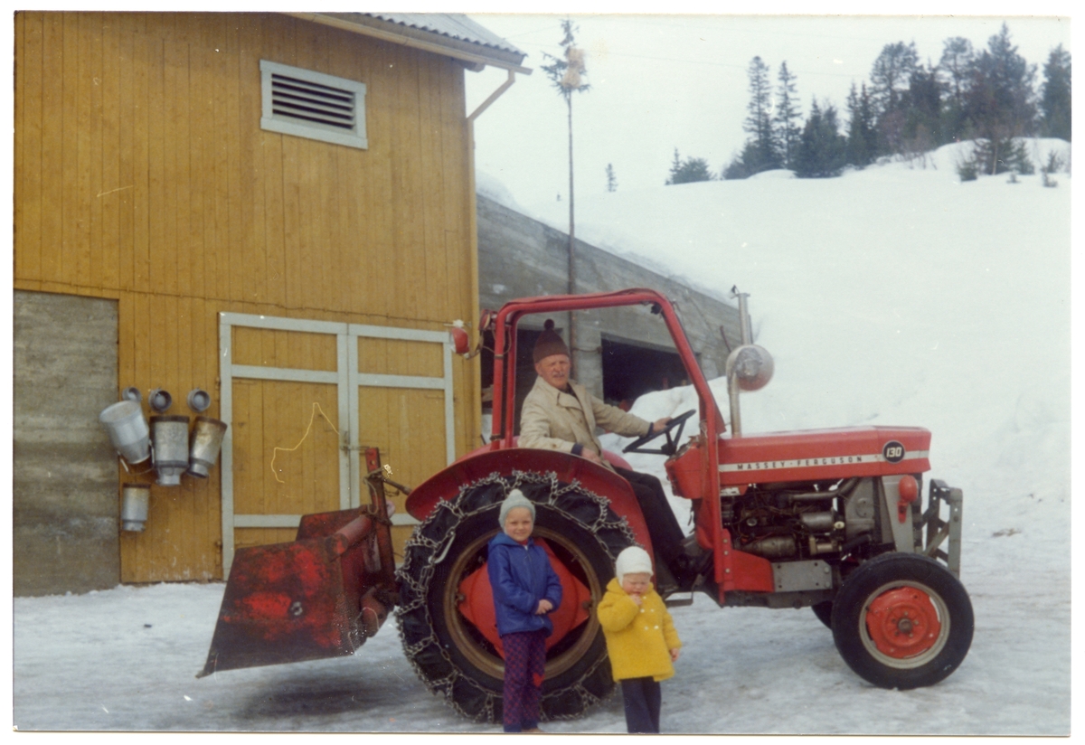 Kristoffer I. Bakken sit i traktoren, ein Massey Ferguson 130. Framfor traktoren står frå venstre: Solbjørg Oldre og Ole Kristian Oldre
