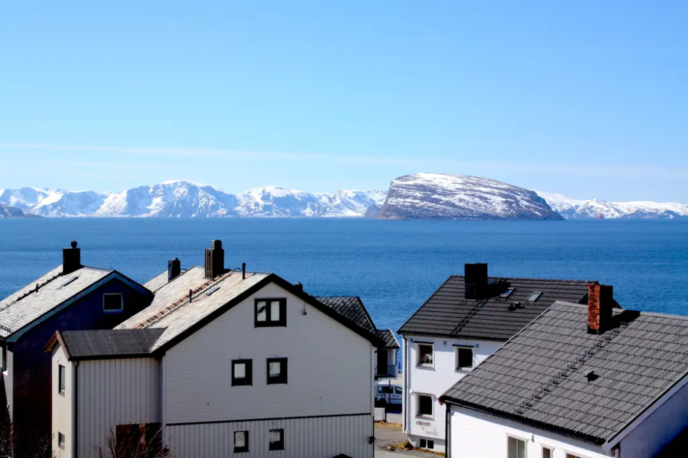 Utsikt fra tårnet til Gjenreisningsmuseet: hus og hav i sollys.