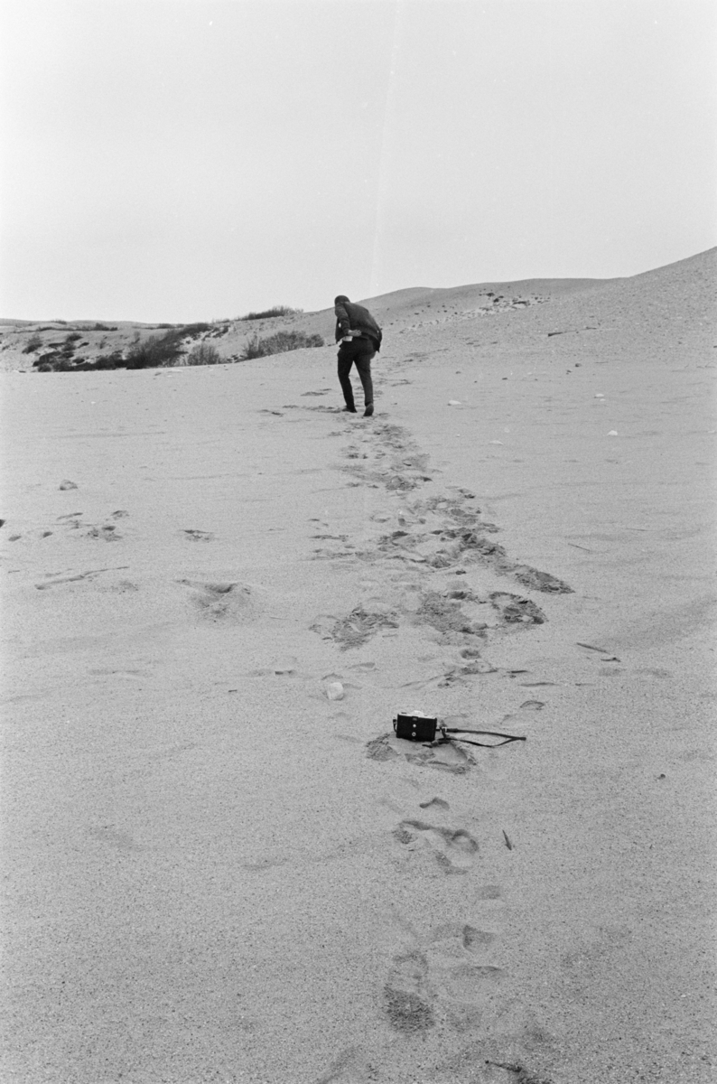 En mann går i sanddyner utenfor Røros.