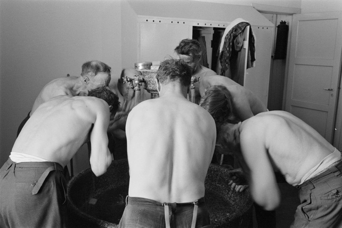 Gruvearbeidere vasker seg i garderoben ved bergverket på Røros.