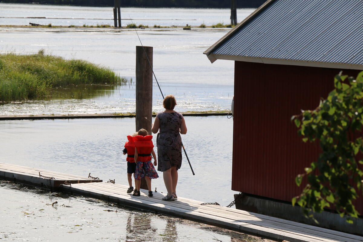 Foto av en familie som skal ut på fisketur ved vannet