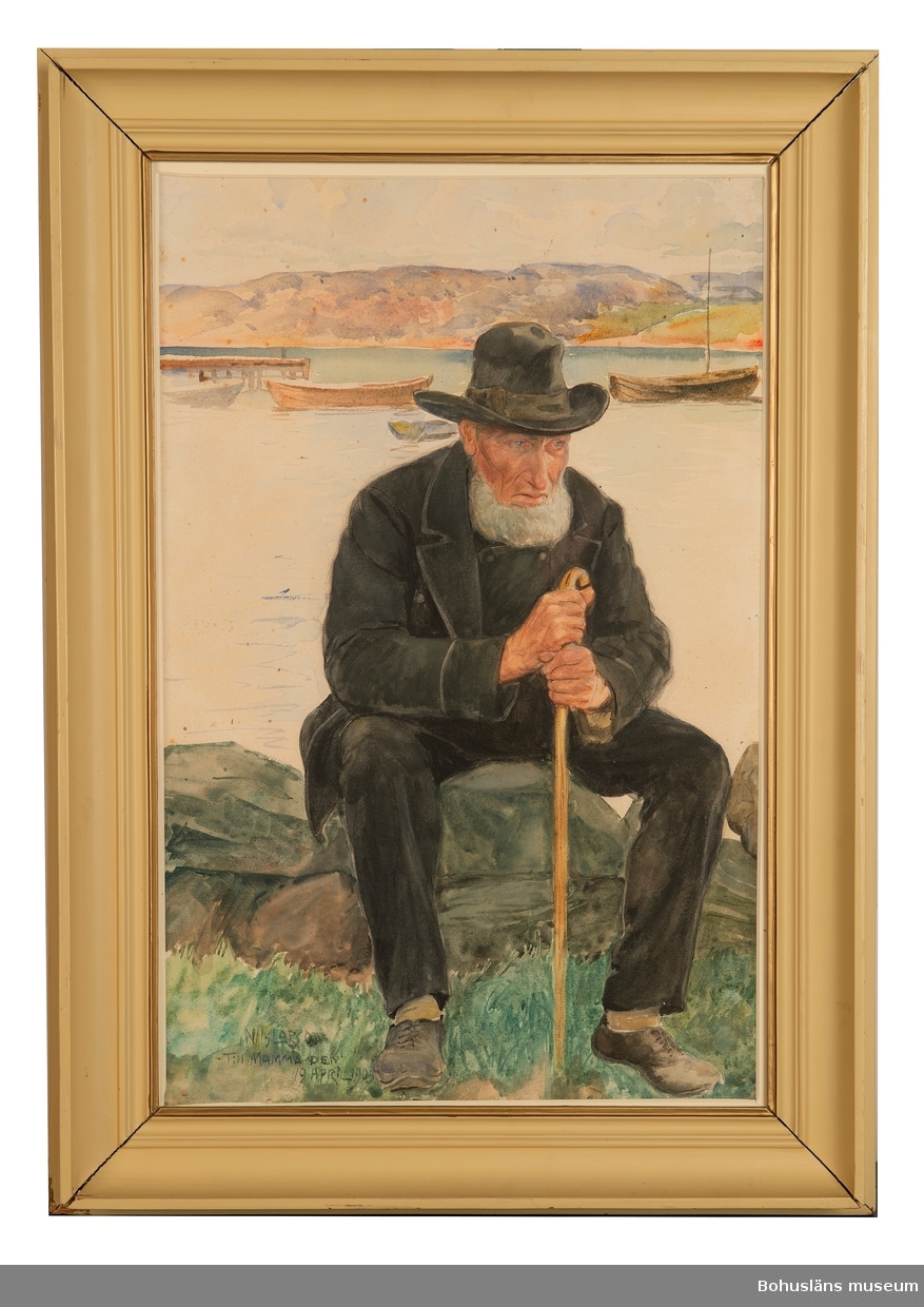Olaus Dahlström, Sannäs, född 1825.
Äldre man med käpp och i mörka kläder och hatt. Han sitter på sten vid strand. I bakgrunden fjord med brygga och båtar.