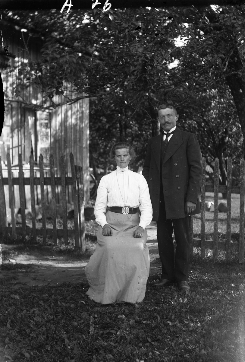 Hilma och Vilhelm Andersson i Dalhem, Grimmared, vid ett spjälstaket intill huset. (Se även bild nr GEA047 och GEA058)
