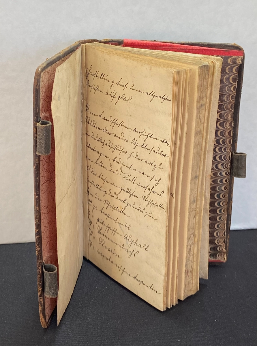 Bok för glasrecept från 1898-1900, författad av okänd person. 
Skinnband, linjerade blad och på bakre pärmens insida finns ett fack för lösa anteckningar. Boken har en "låsanordning" i form av tre öglor, i vilka man för in en penna, som fungerar som "lås".