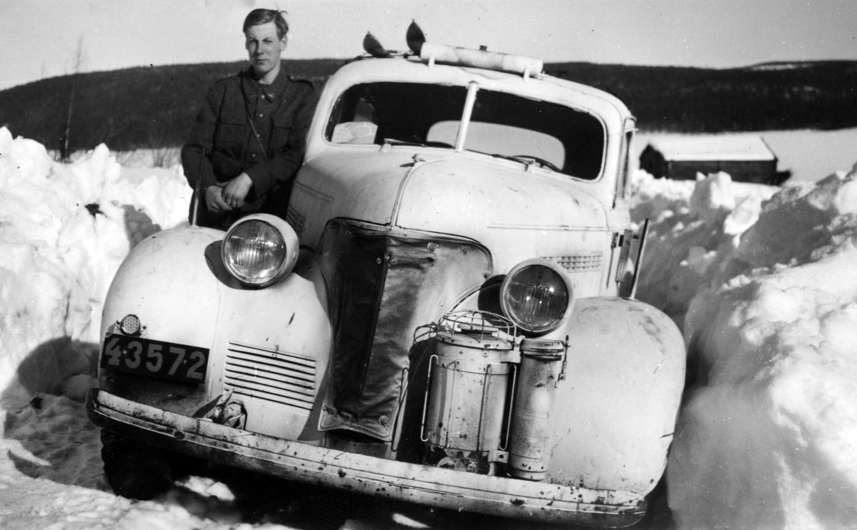 Hantverkare Johansson från Kalmar stående bredvid en personbil av sorten Volvo m/39 gengas.  Vinter på 1940-talet