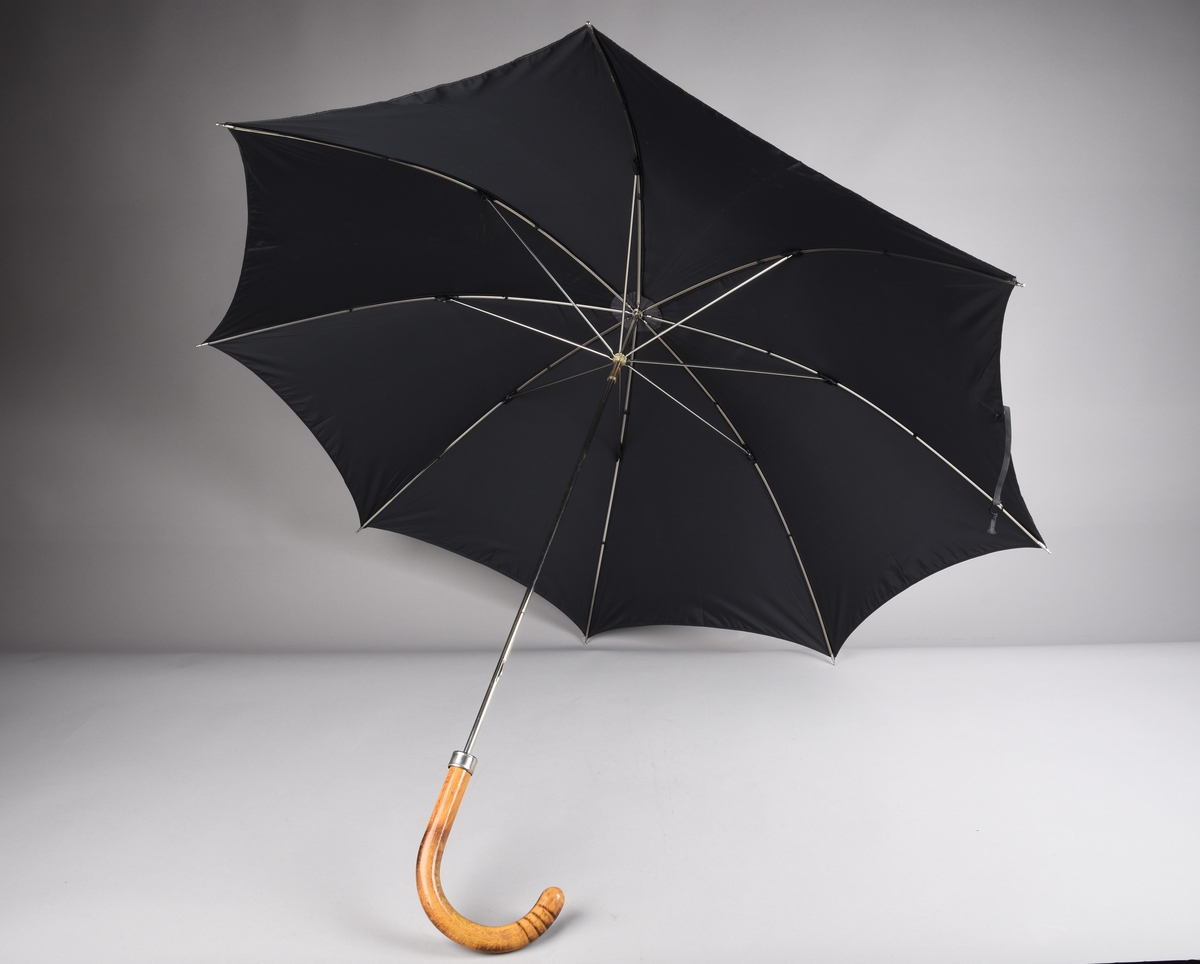 Paraply med 8 spilar og stong i metall. Handtak i tre.