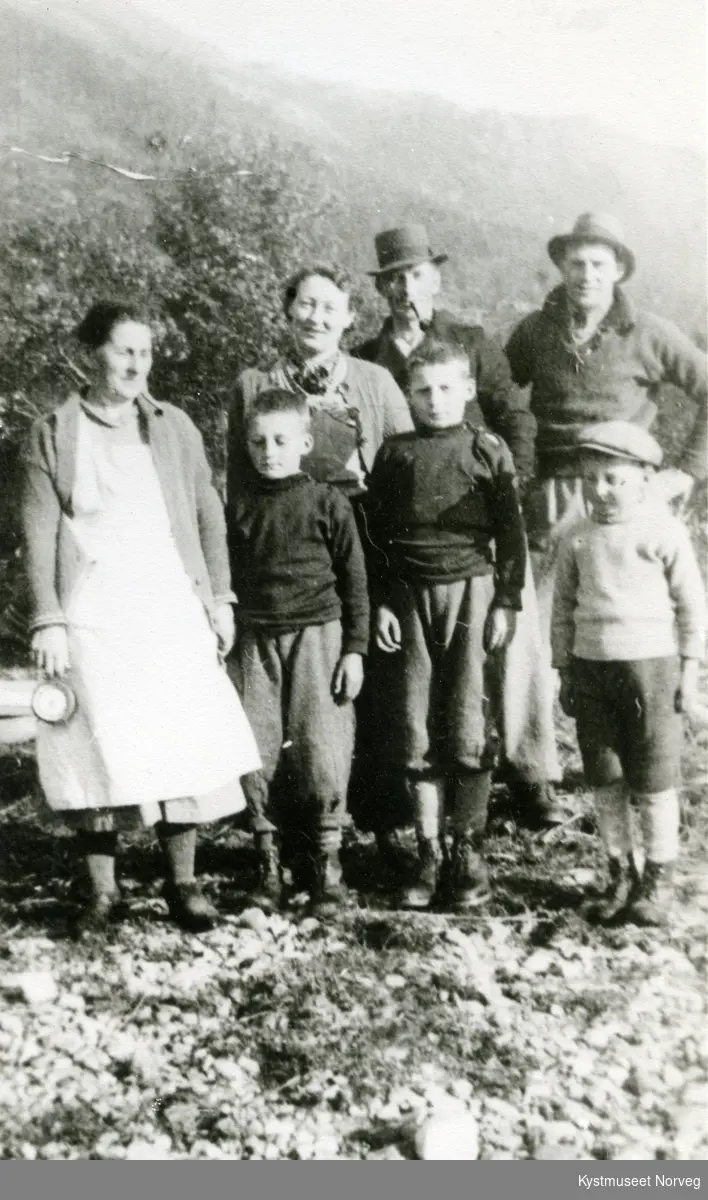 Ingeborg Einvik i midten med familie i strandkanten i Einvika, Flatanger