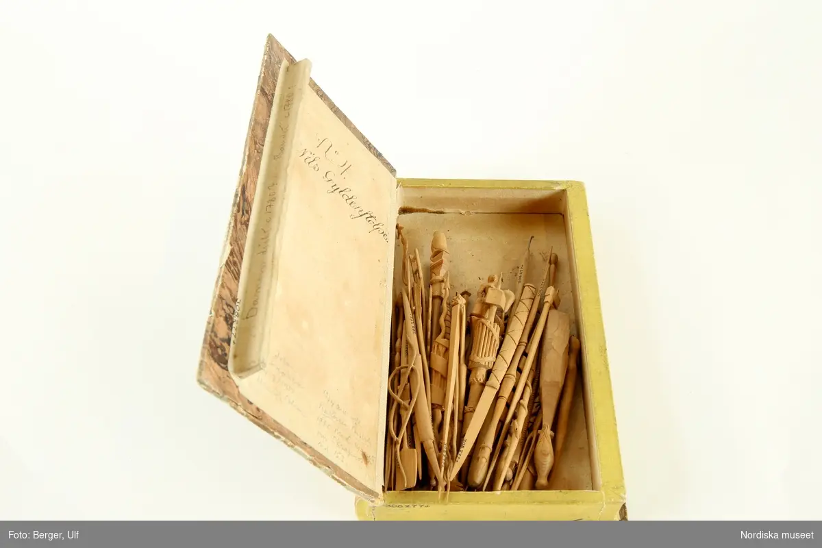 Skrapnosspel med 55 spelpjäser, stickor, av skuret trä. Stickorna avslutas av olika figurer som föreställer redskap, vapen, musikinstrument, djur och en kvinna i 1700-talsdräkt. En spelpjäs är ofullbordad. Förvaras i ask som liknar en inbunden bok ("Dr Faustus lefverne"). Inuti asken finns en anteckning med svart bläck: "No 4 Nils Gyldenstolpe" samt med annan stil bl a "60 delar + kroken 24.7 1951 Henrik Alm".
/Anna Womack 2005