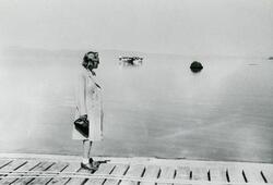 En ukjent dame står på dampskipskaia i Vadsø havn i 1947. I 