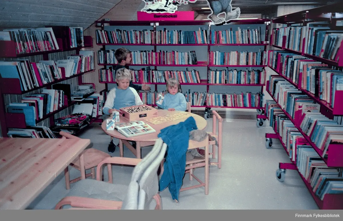 Innvielse av Båtsfjord bibliotek 1986. I barnekroken barna har allerede tatt spillene i bruk. De har fått "Fanta juice" til å drikke i forbindelse av innvielsesdagen.