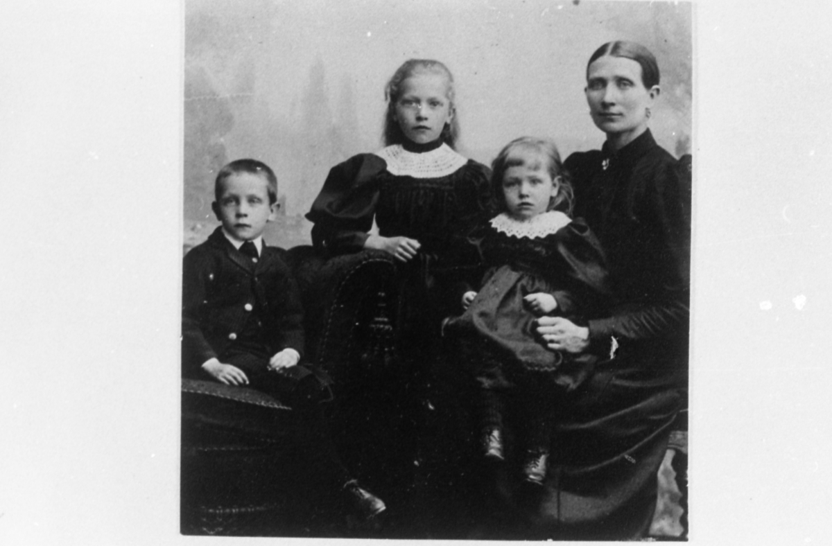 Ateljéfoto av Hanna Eleonora Johansson och de tre yngsta barnen cirka 1894. Hanna född i Bölet 1855, död 1943 Heljered Mellangård "Klockarns" 1:7. Änka år 1893. De tre yngsta barnen, från vänster: 1. Elon (född 1889). 2. Selma (född 1887). 3. Annie (född 1892).