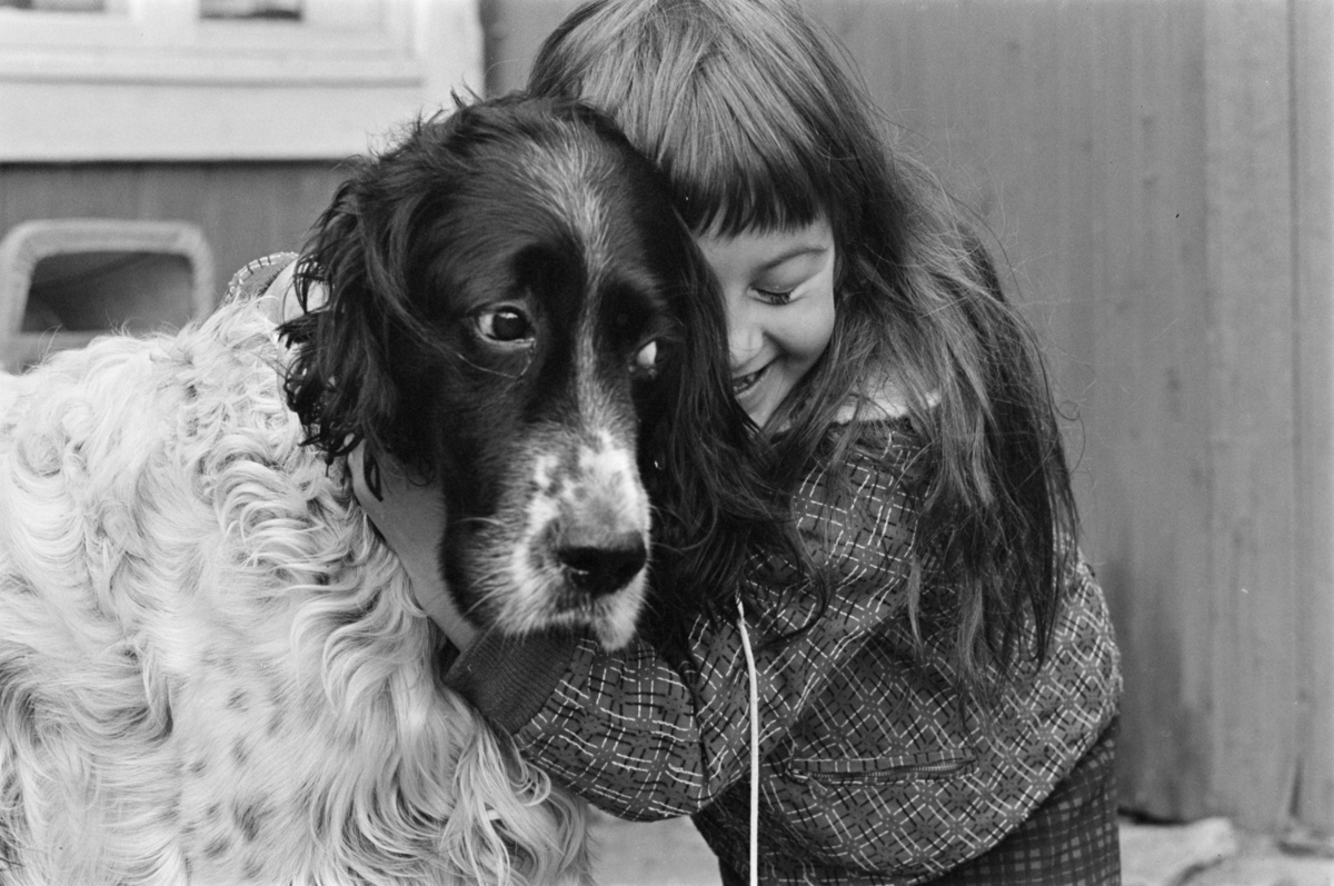 Portrett av et barn som koser med en hund.