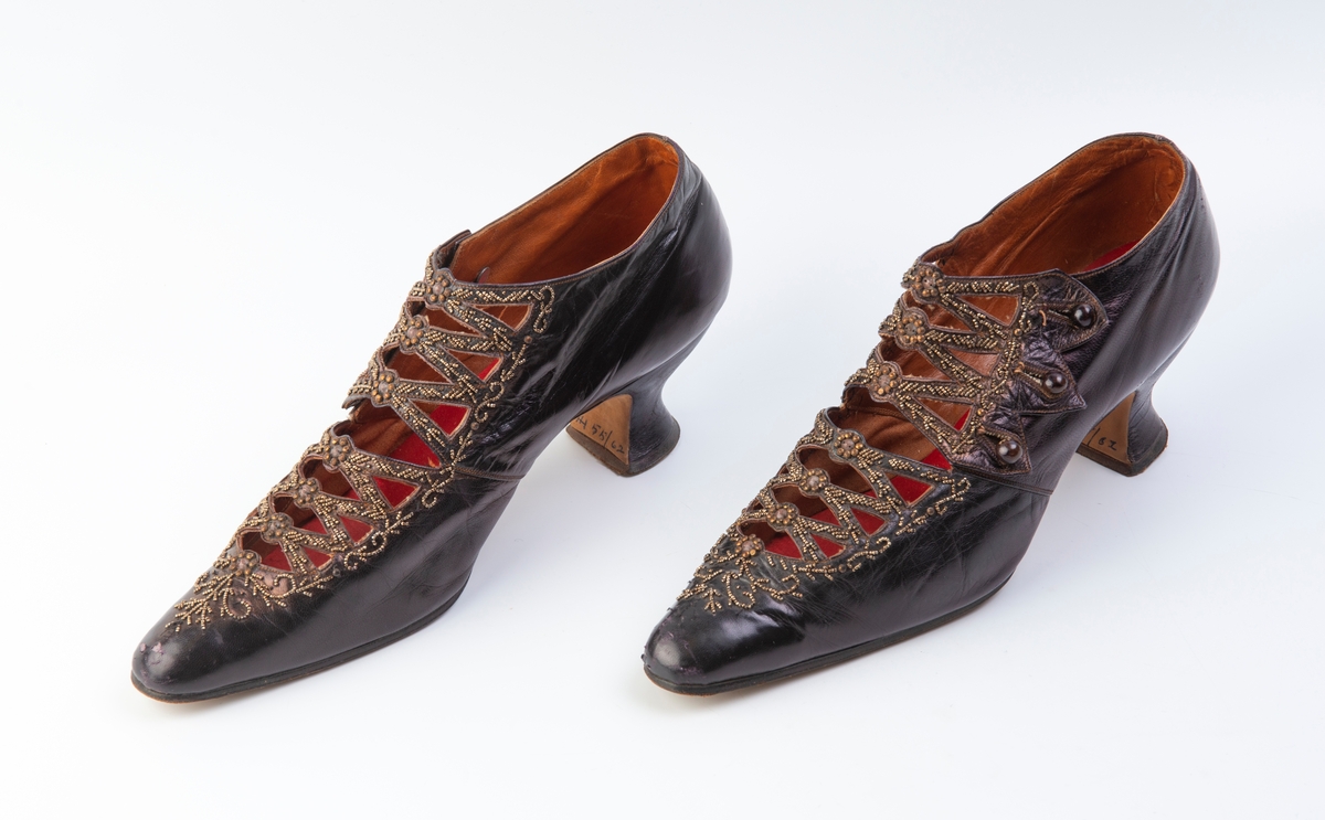 Mørk-fiolett, rødt trekk over sålene.
Stemplet under sålen: 1529 236(?)
Perlebroderi.
3 Knapper på hver sko.