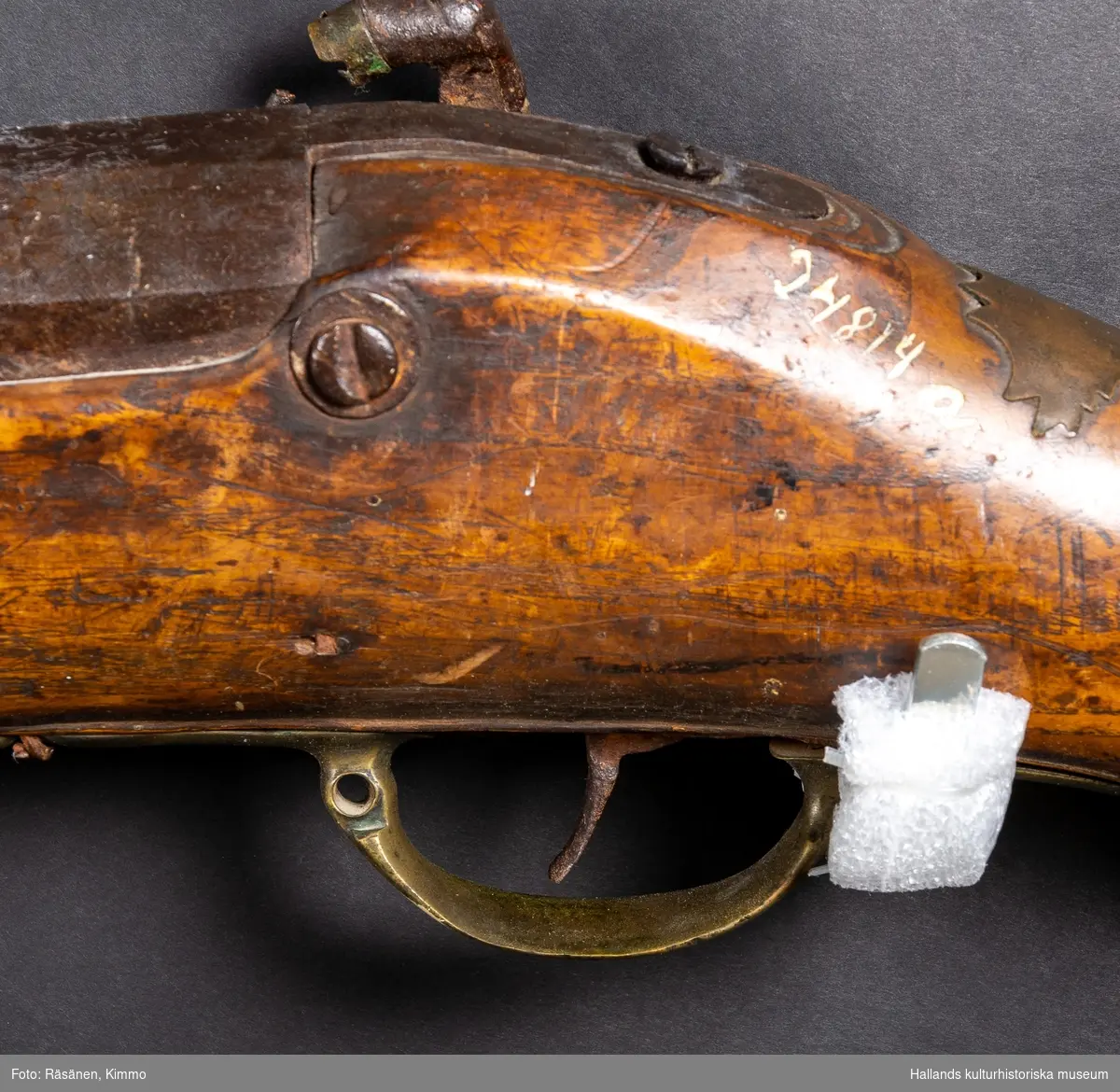 a) Sälbössa, kaliber 23 mm. Godset tjocklek vid mynningen 10 mm. Pipans längd 108,5 cm. Med åttakantig pipa, refflad, knallhattslås, såväl pipa som kolv ornerade, laddstock av trä, beslag av mässing. 
b) Kulpung av skinn, kork saknas. Mått: längd 15 cm, cirka.