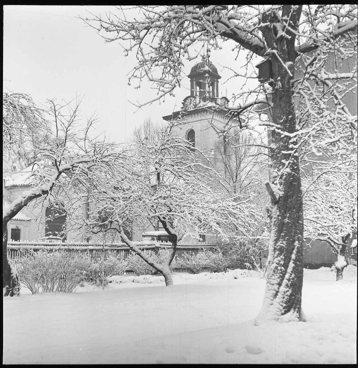 Snö kring Stadskyrkan sedd från en trädgård i kv Liljan, dec 1950.