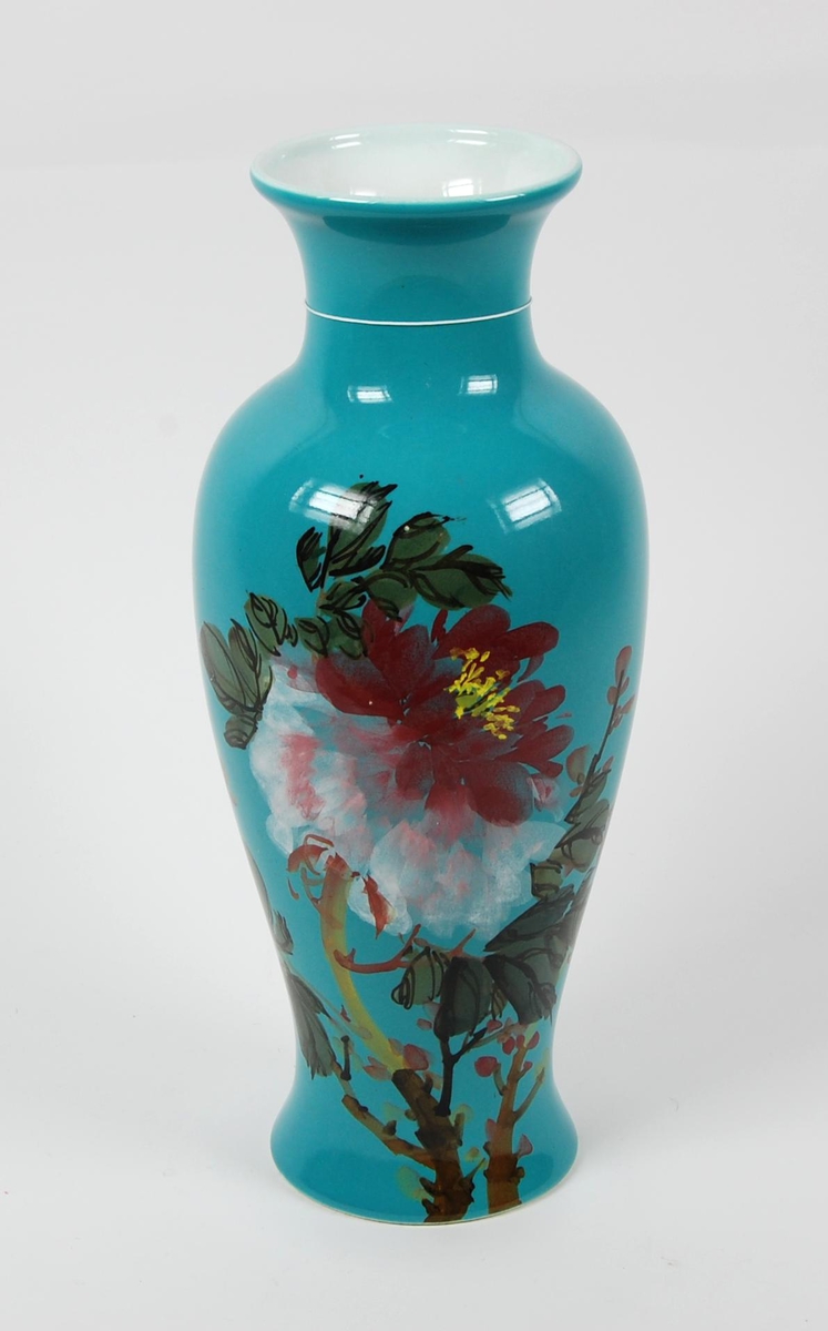 Turkisfarvet vase med en påmalt blomst i ulike farger.