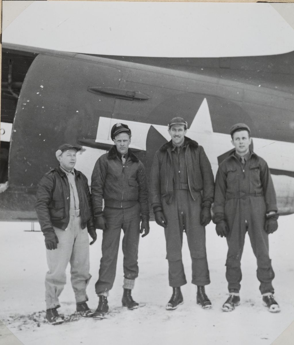 Fire besetningsmedlemmer oppstilt foran sitt DC-47 transportfly ...