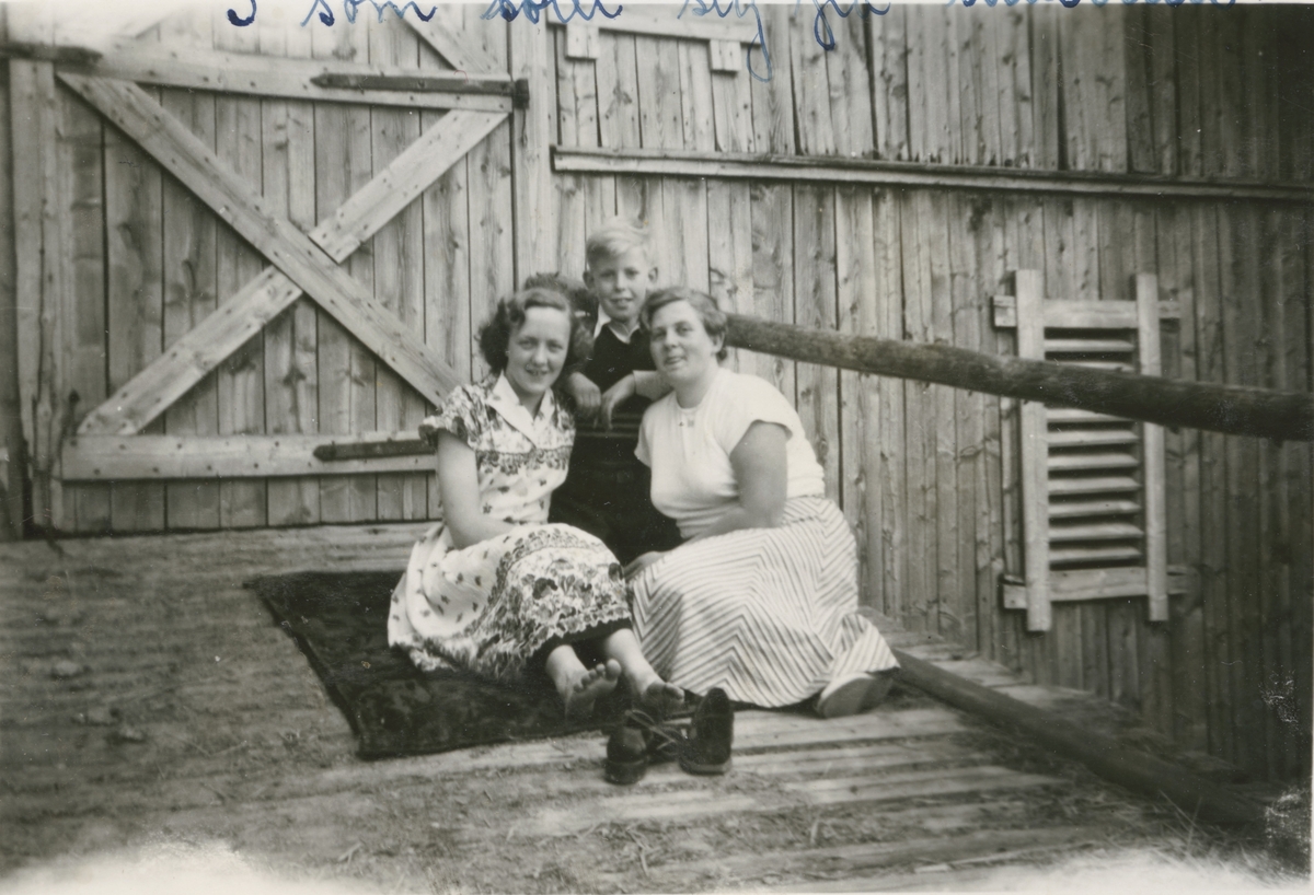 Borghild, Kjell Rud og Karen Rud sitter på låvebrua, Rud gård i Gjerdrum ca. 1950.