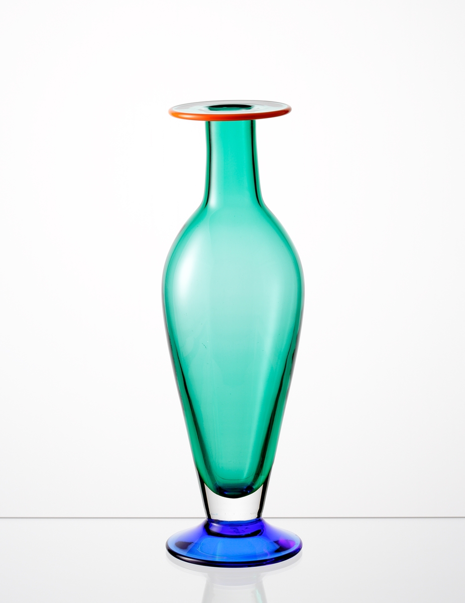 Formgiven av Erika Lagerbielke. Amforaformad vas med utvikt mynning. Grönt underfång med orange mynningsrand, samt blå fot. Ingick i en serie om sammanlagt fem vaser (OF 2778 - OF 2782). Serien slopades 1997.