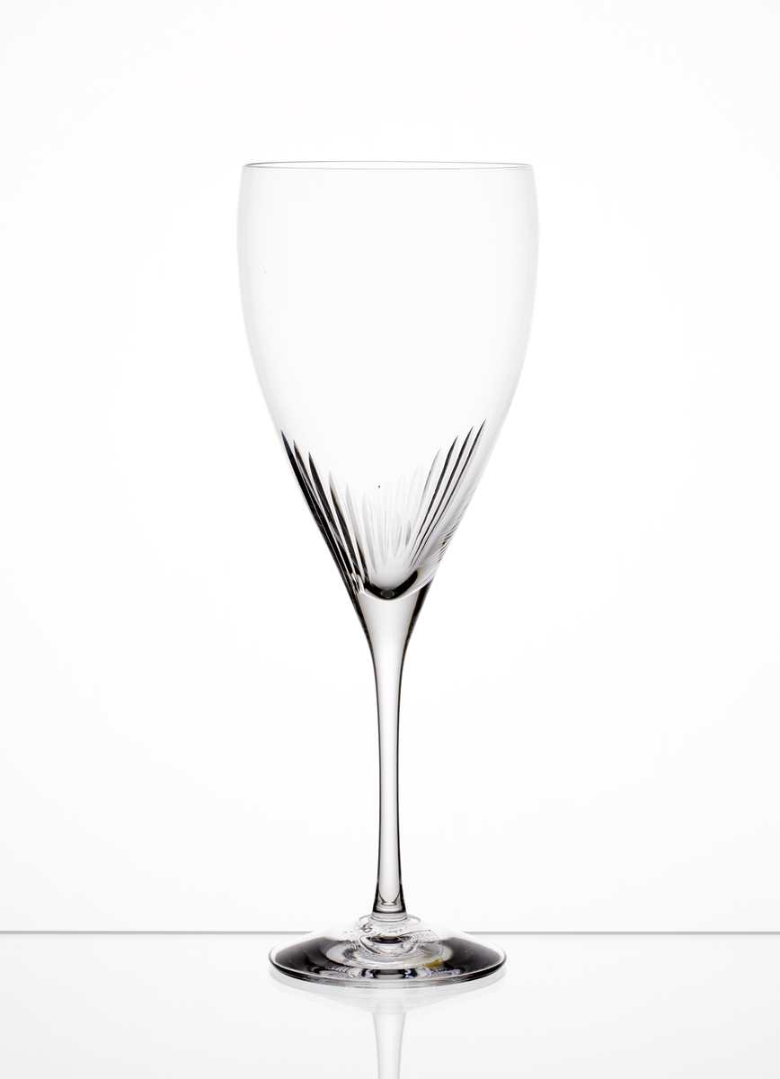Formgiven av Erika Lagerbielke. Ölglas med nio plus nio stående skär placerade där skålen övergår i ben. Genomskinlig etikett med orre och text i silver.