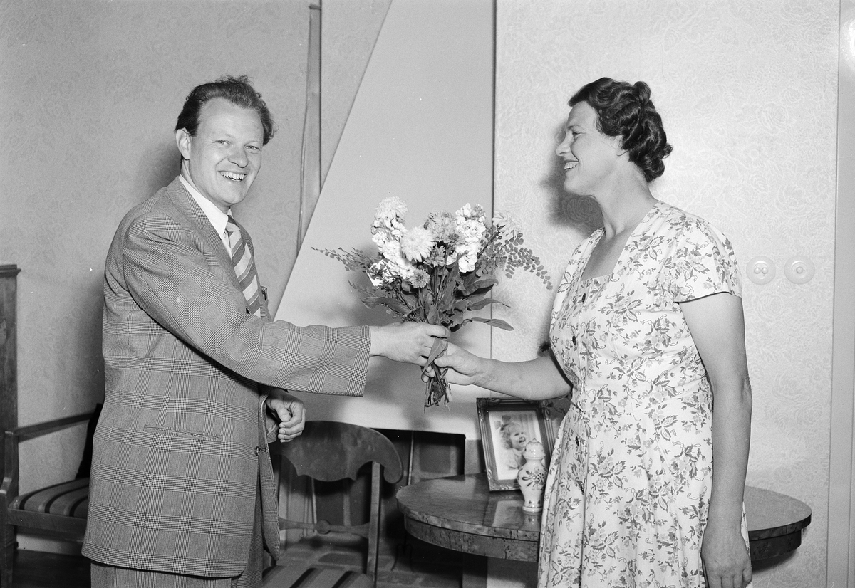 En man överräcker en blombukett till en kvinna, Sala backe, Uppsala 1950