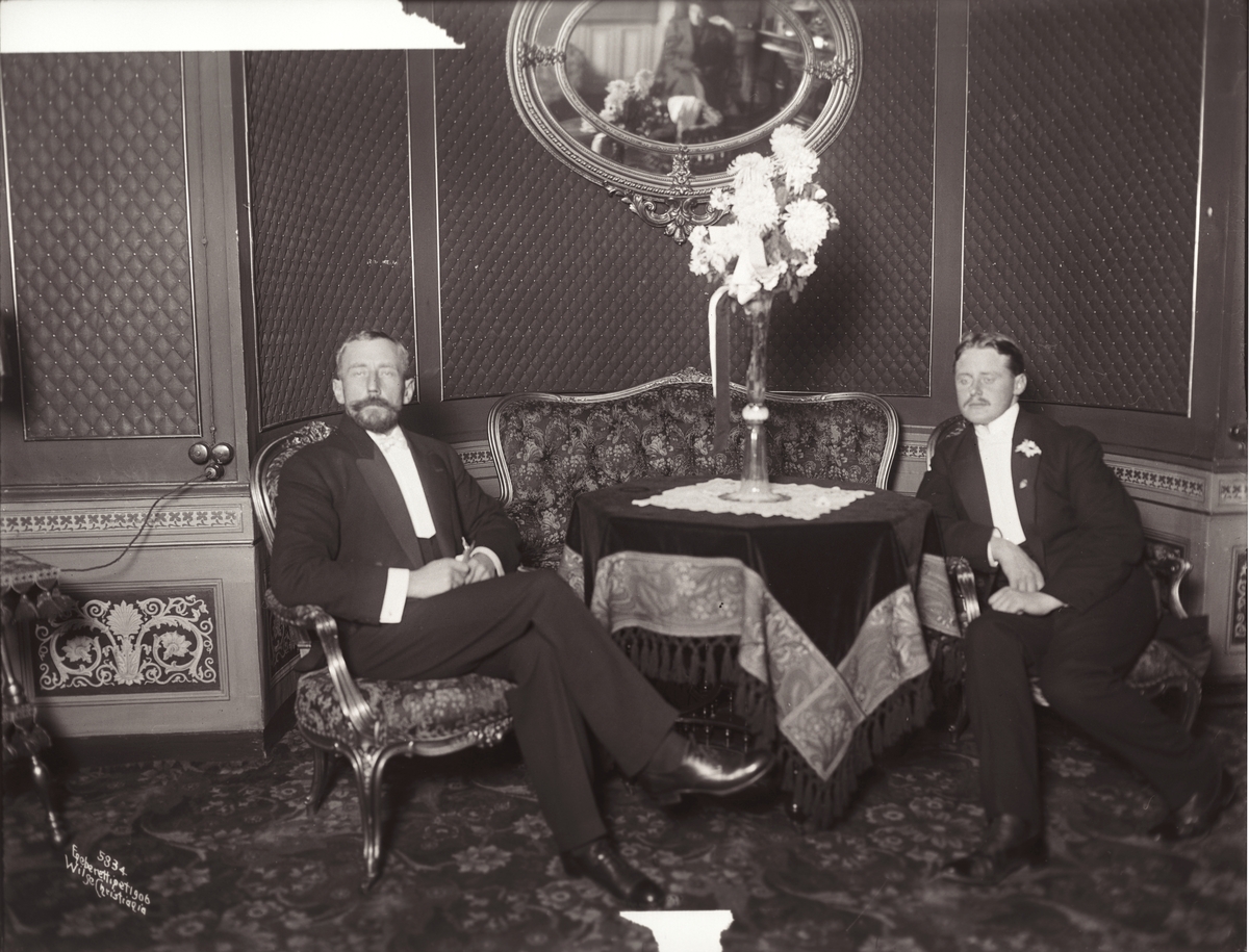 Roald Amundsen (t.v) og Godfred Hansen sitter festkledde på Grand hotel 21. november 1906.