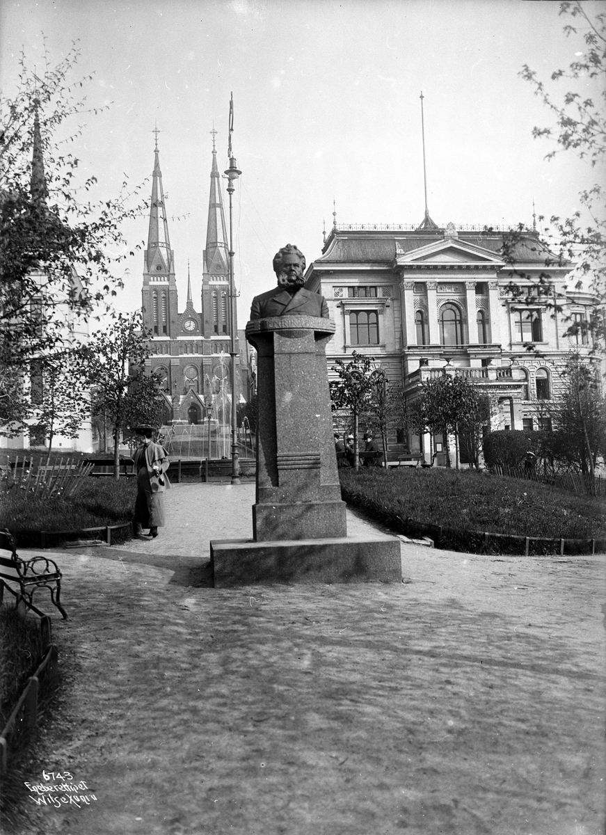 Støtte av Ibsen står i Ibsenparken. Bak sees Skien kirke. Fotografert i 1907.