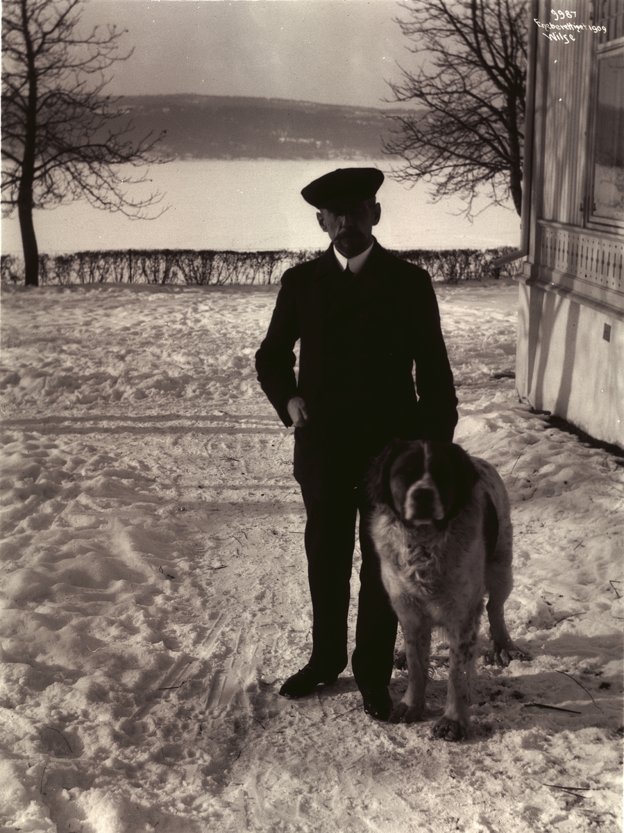 Roald Amundsen og hunden utenfor villaen Uanienborg. Fotografert 7. mars 1909.