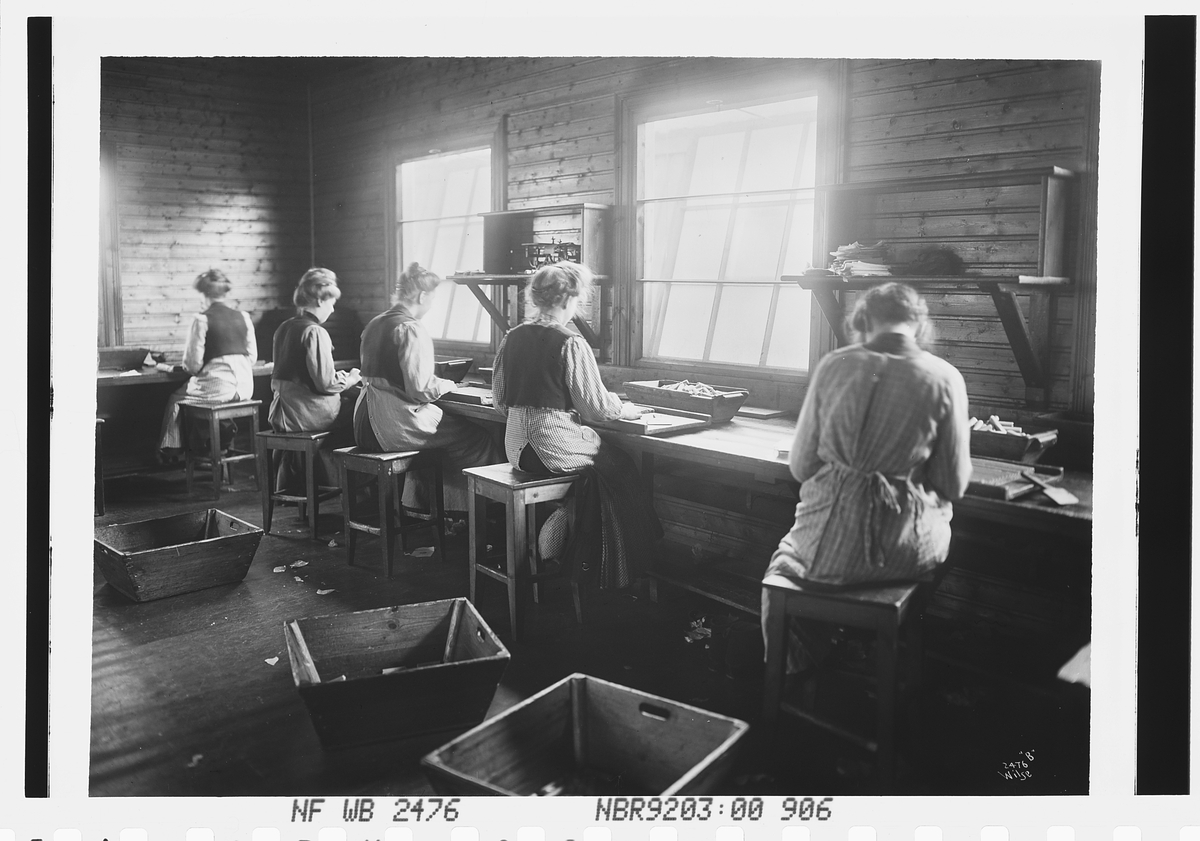 Kvinner i arbeid med pakking av dynamitt i fabrikken.