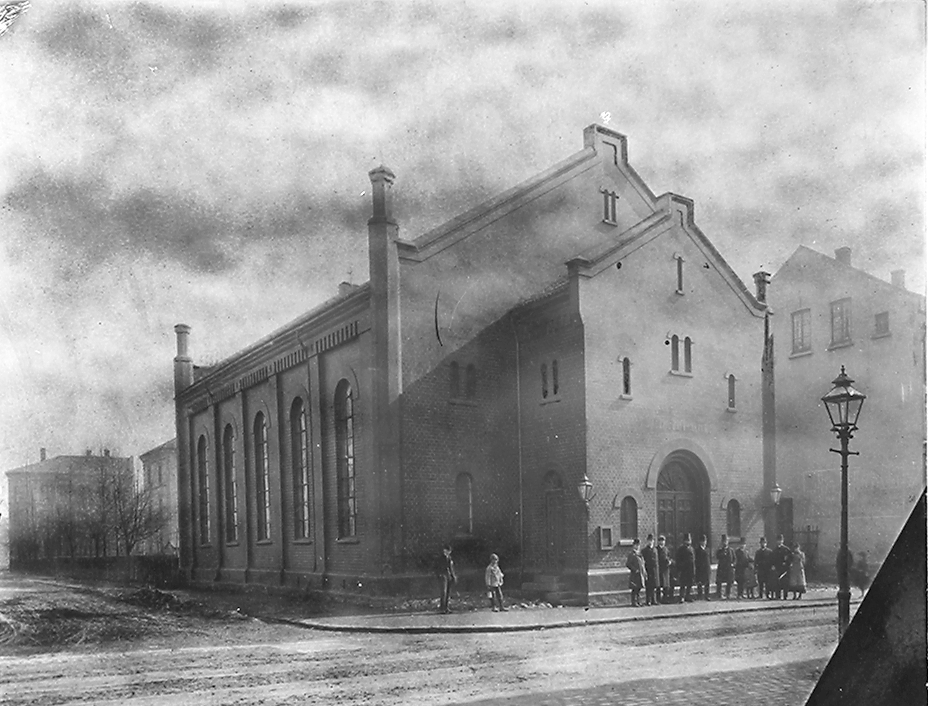 Boktrykker Gundersen sammen med menn foran fabrikkbyging. Fotografert 1923.