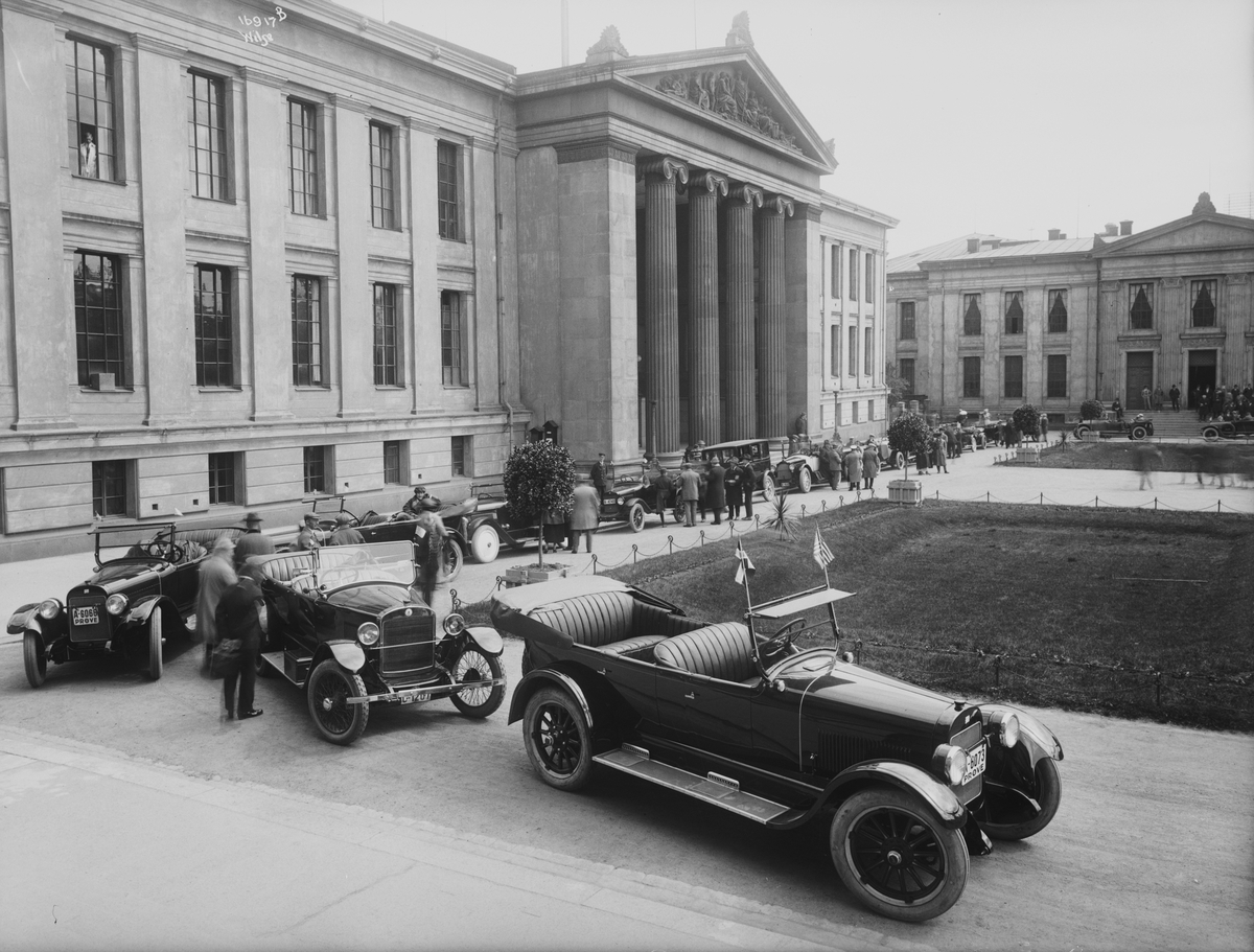 Mange biler er samlet ved Universitespalssen. "Kristiania Rotary Klubs biltur til Sundvolden for America Koret 6/6-23" tekst på bildet (NF.WB16918). Fotografert 06.06.1923.