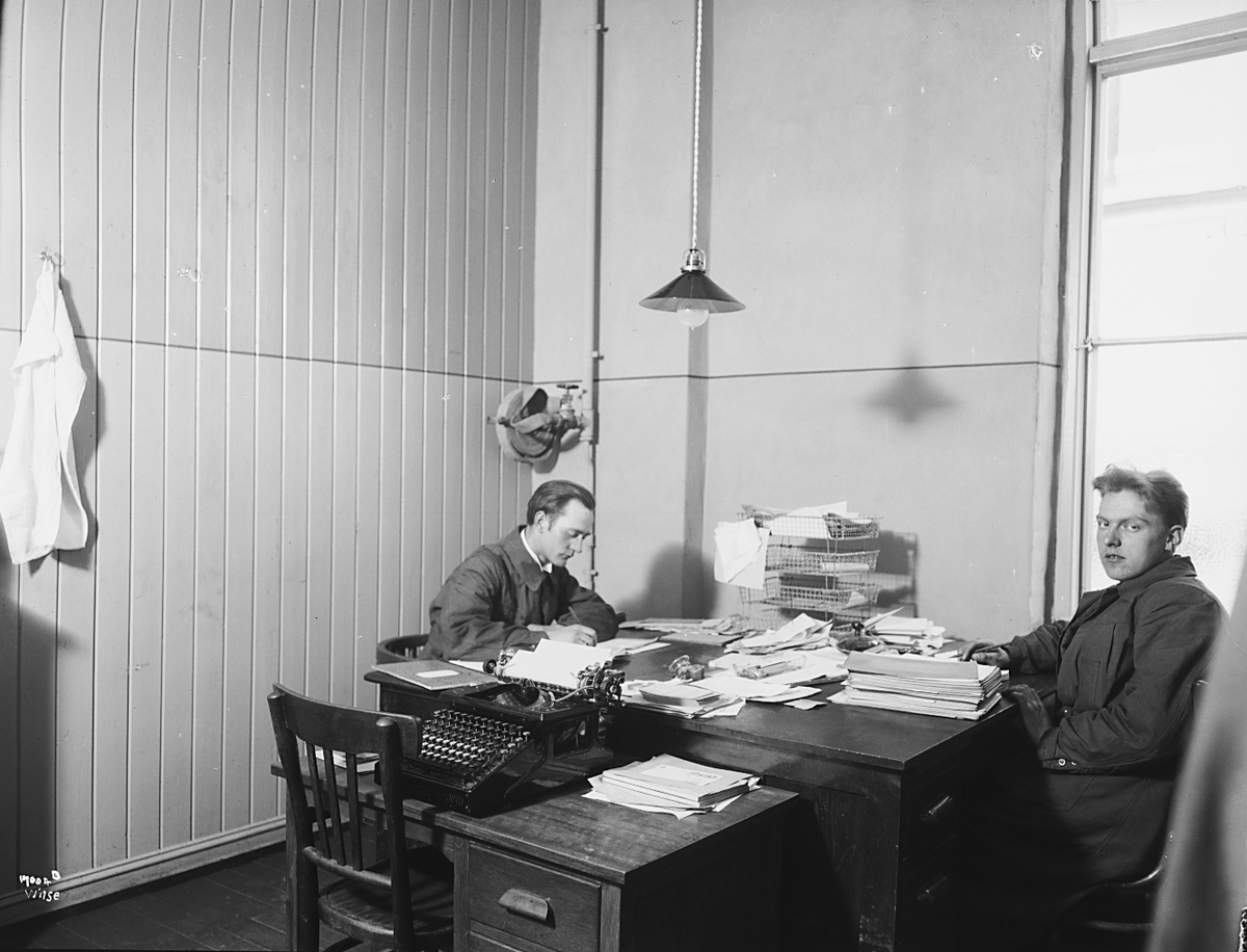 To kontorister sitter ved skrivebord, Sørensen og Balchen A/S. Fotografert 1923.