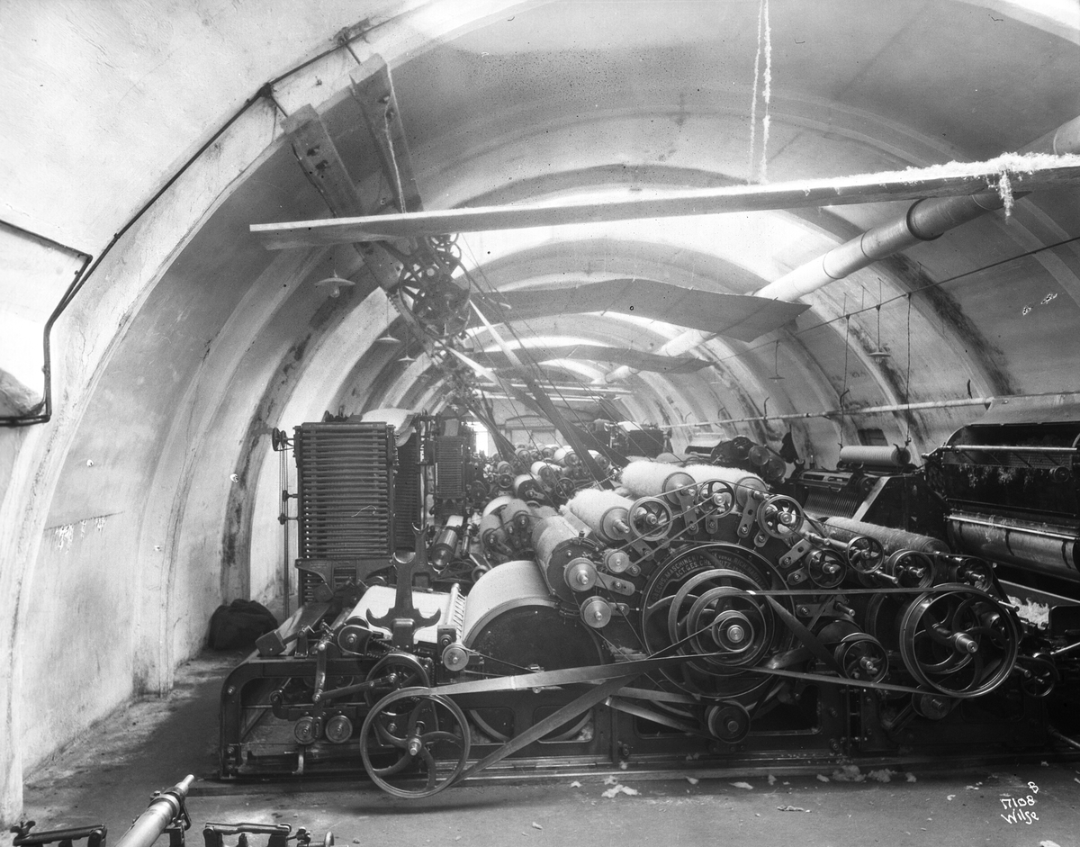 Mange vevemaskiner står i en hall, Heggdal Ullvarefabrikk. Fotografert 1923.