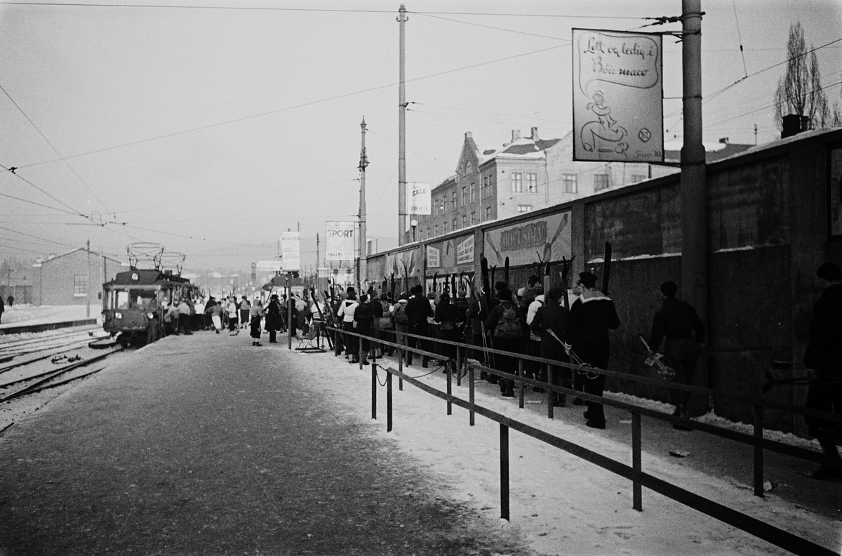 Kø med skikledde mennersker på Holmenkollbanen ved Majorstuen Stasjon. Fotografert 1940.