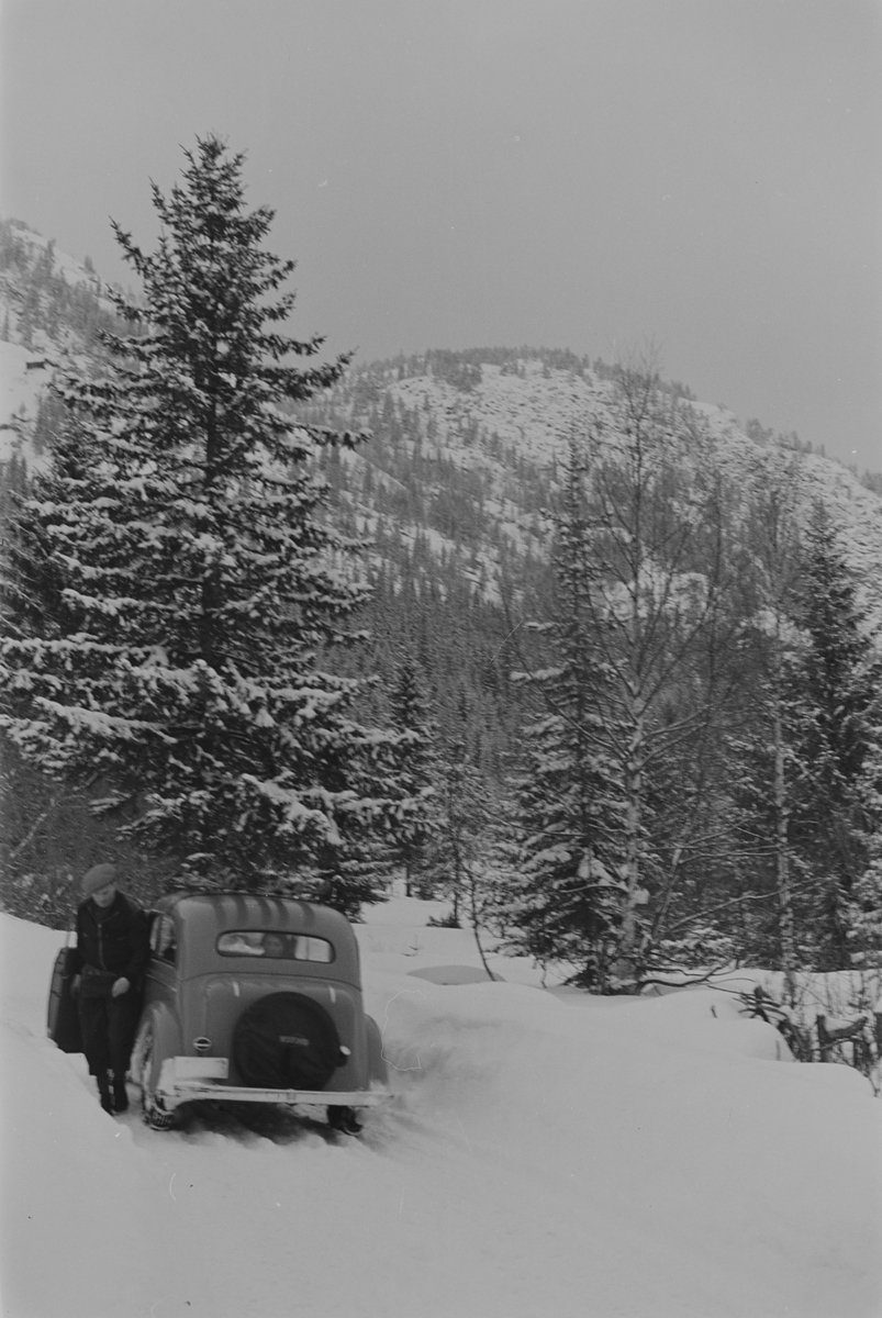 Mann forlater bil på snødekket vei i Gausdal i påsken. Fotografert 1940.