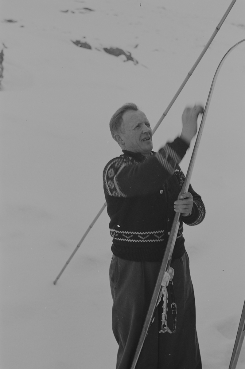 Mann i som smører skiene. Fotografert 1940.